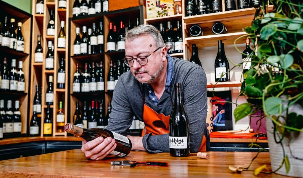 Didier présente l’étiquette d’une bouteille