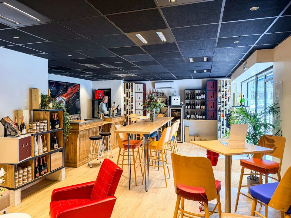 La salle du ReVerre : comptoir en bois, tables hautes et fauteuil rouge
