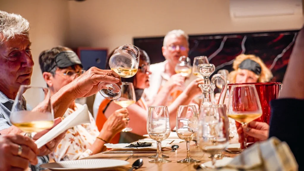 Une tablée lève ses verres de vin blanc